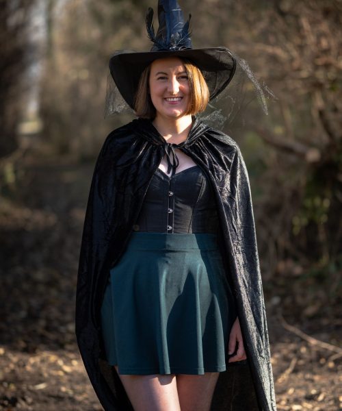 Gwen en cape et chapeau de sorcière, debout dans la nature